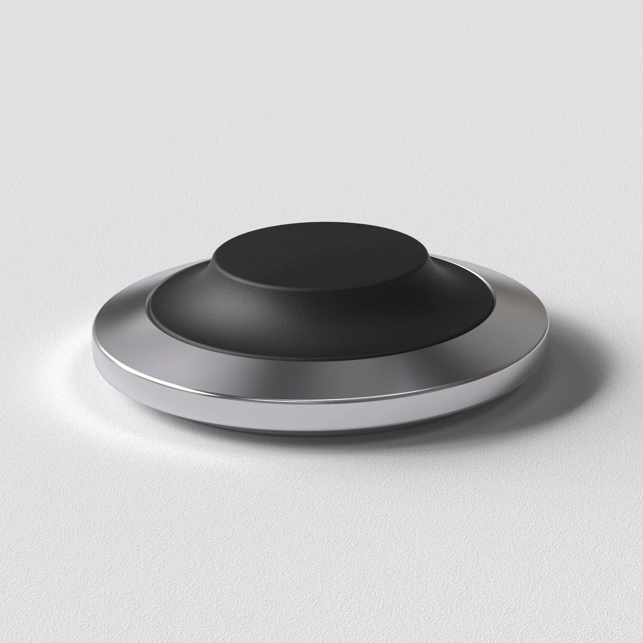 STILL wireless charging dock with a low stainless steel base and replaceable soft cap, designed for a fixed place at home.